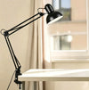 Flexible Adjustable Swing Arm Clip Desk Lamp positioned on desk, providing focused task lighting.