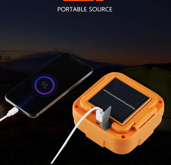 Portable LED Solar Power Flood Light charging a phone with solar energy, showcasing portability and convenience.