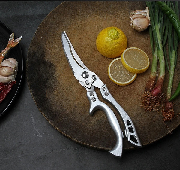 Chicken Shredder Tool placed on a wooden board with lemon and green onions, ideal for shredding cooked meats.