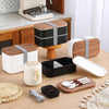 Lightweight Microwave-Safe Bento Lunch Box assortment on a wooden table with utensils and containers.