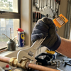 Hand using a Professional Adjustable Torque Wrench on copper pipes in a workshop.