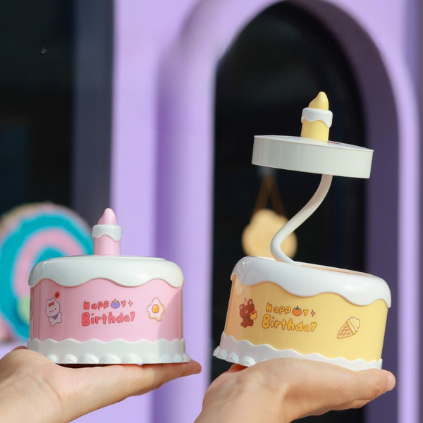 Portable LED Cake Desk Lamp displayed in hands, featuring playful birthday designs and warm glow.