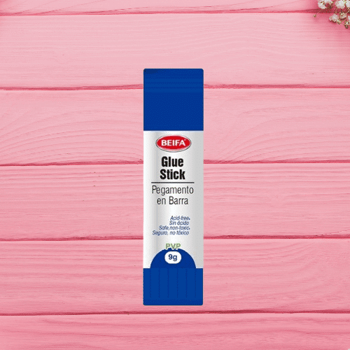 Quick-Dry Mini Glue Stick 9g – School & Office Adhesive in a blue package on a pink wooden background.