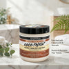 Nourishing Coconut Oil Hair Conditioner in a jar on a marble counter with plants.