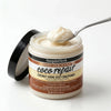 Nourishing Coconut Oil Hair Conditioner in a jar with a spoon, featuring a creamy texture for deep hydration.