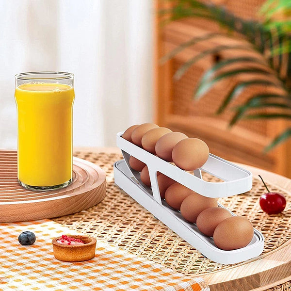 Refrigerator Egg Rolling Organiser for Storage holding eggs next to a glass of orange juice on a wooden table.