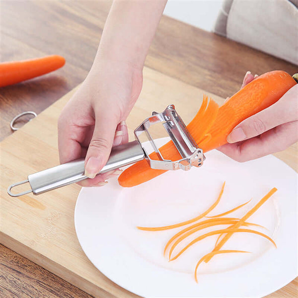 Person using Stainless Steel Handheld Vegetable & Fruit Peeler on a carrot with peels on a white plate.