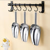 Stainless Steel Ice Scoop set with three scoops hanging on a rack in a kitchen.