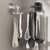 Suction cup wall hooks for storage holding kitchen utensils and a towel on a smooth wall surface.