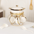 Ceramic Soup Tureen Set with Bowls and Spoons, elegantly displayed with a gold holder and accessories.