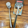 Double-Sided Stainless Steel Meat Tenderiser Hammer and packaging on wooden surface.