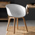 Modern White Dining Tub Chair featuring a smooth polypropylene seat and sturdy wooden base in a stylish dining setting.