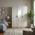3 Door Wardrobe with Centre Mirror in Light Oak Finish in a modern bedroom setting with a cozy bed and natural decor.