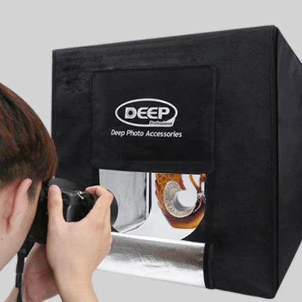 Photographer using a 60x60cm LED Deep Professional Photography Studio Light Box for product photography.