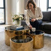 Lucid Gold 3-Piece Nesting Coffee Table Set showcased in a stylish living room with a woman enjoying coffee.