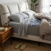 Modern Upholstered Bed Frame with soft bedding and stylish decor in a contemporary bedroom setting.
