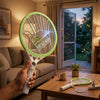 A person holding a Palm Mesh Core Electric Mosquito Swatter indoors, ready to swat flying insects.