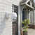 V380 Pro PTZ Outdoor Security Camera mounted on a white brick wall near a front door, providing surveillance.
