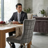Grey Upholstered Dining Chair with Silver Frame in modern dining setup with a man in a suit.