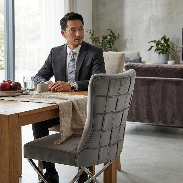 Grey Upholstered Dining Chair with Silver Frame in modern dining setup with a man in a suit.