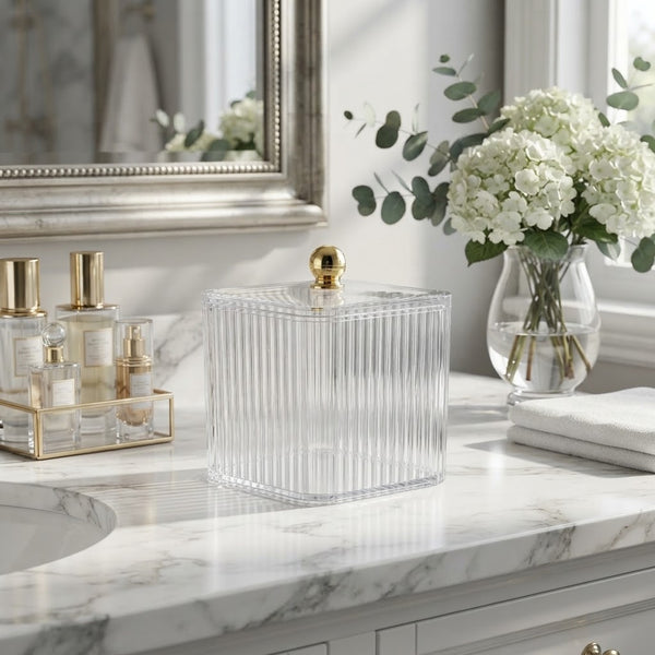 Clear Ribbed Acrylic Storage Box with Dust-Proof Lid on a marble countertop next to beauty products and flowers.