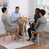 Round Glass 5 Piece Dining Set with Fabric Chairs featuring four people around the table enjoying refreshments and conversation.