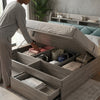 A person accessing the storage compartments of a Solid Wood Storage Bed Frame with under-bed storage.