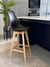 Fusion Living Aqua Soho Plastic Bar Stool in a modern kitchen setting with sleek design and wood legs.