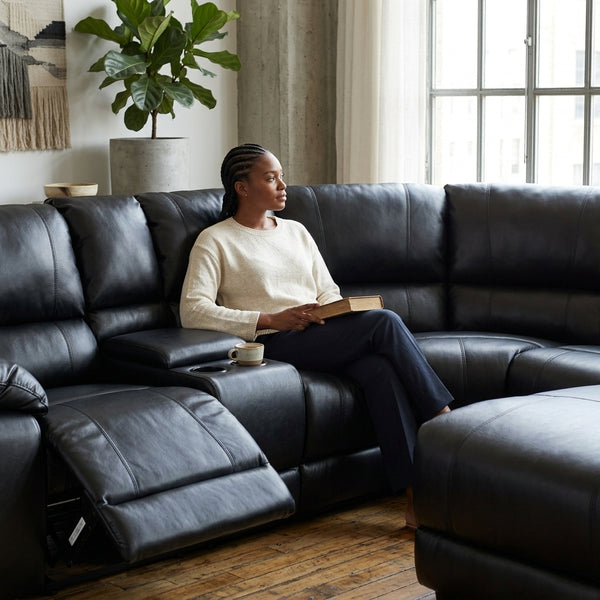 Wembley Luxury Recliner Sectional Couch featuring a woman relaxing with a book and coffee in a stylish living room.