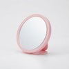 Round Portable Makeup Mirror in pink, offering a convenient reflective surface for makeup and grooming tasks.