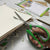 Close-up of Stainless Steel Office Scissors cutting through paper on a desk with craft materials.