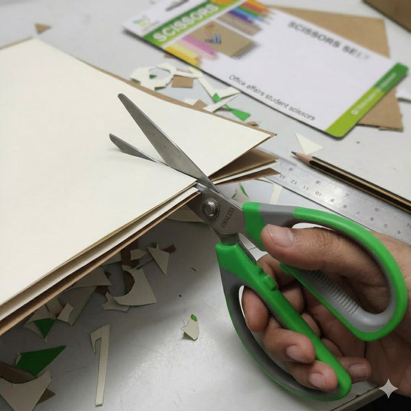 Close-up of Stainless Steel Office Scissors cutting through paper on a desk with craft materials.