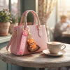 Cartoon Animal Keychain attached to a pink handbag on a cafe table with a coffee cup.