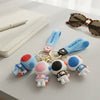 3D Silicone Astronaut Keychain set on a desk with sunglasses, showcasing colorful astronaut designs and keyring attachment.