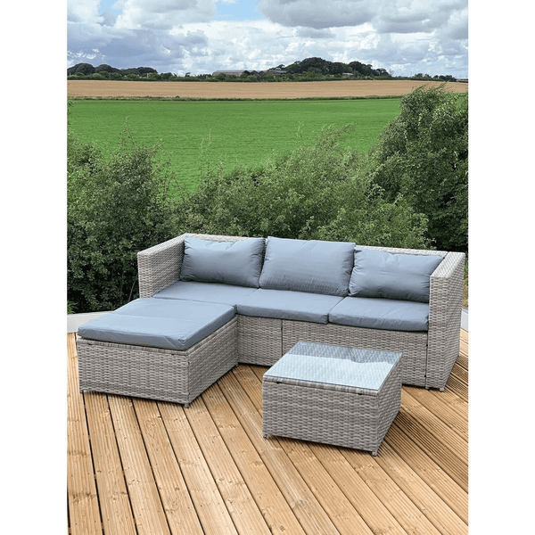 Garden Lounge Set with Grey Cushions on a wooden deck with green fields in the background.