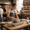 Baker using Square Nonstick Aluminum Bread Loaf Pan with freshly shaped dough in a rustic bakery setting.