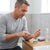 Man applying Tsunami Active Paste Plant Extract Ointment on his wrist at home.