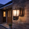 Solar Wall Light Security Camera Unit mounted on a brick wall, illuminating the entrance with exterior surveillance.