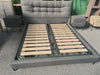 Elegant Upholstered Sleigh Bed featuring padded headboard and wooden slats for durability and comfort.