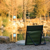 Ultra-Lightweight Folding Portable Camping Chair by a serene lake surrounded by trees in the background.