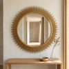 Stylish Sunburst Decorative Round Wall Mirror reflecting light in a modern hallway setting.