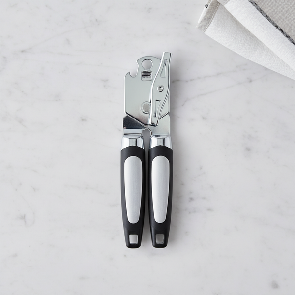 Heavy-Duty Polished Stainless Steel Manual Can Opener on a marble countertop with a dish towel.