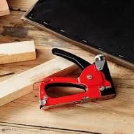 GS Manual Nail Staple Gun on a wooden surface with wooden blocks for DIY and repairs