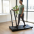 Woman exercising on the Cross-Border Electric Home Treadmill with LED Display in a bright home environment.