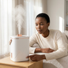 Woman using the 1.8L USB Nano Spray Humidifier, enjoying a fine mist of moisture indoors.