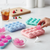Flower-Shaped Silicone Ice Cube Tray with colorful ice cubes and a hand retrieving a cube.