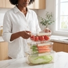 Person organizing fresh vegetables and tomatoes in the Deluxe 5-Piece Stackable Airtight Food Container Set.