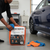 Person holding the 9-Piece Car and Motorcycle Cleaning Kit with Bag in a garage setting, ready for vehicle cleaning.