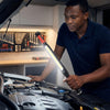 A person using a Rechargeable Magnetic LED Work Light Bar while working under the hood of a car.