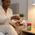 Person applying Mosquito Liquid Refill to an electric vaporizer on bedside table.